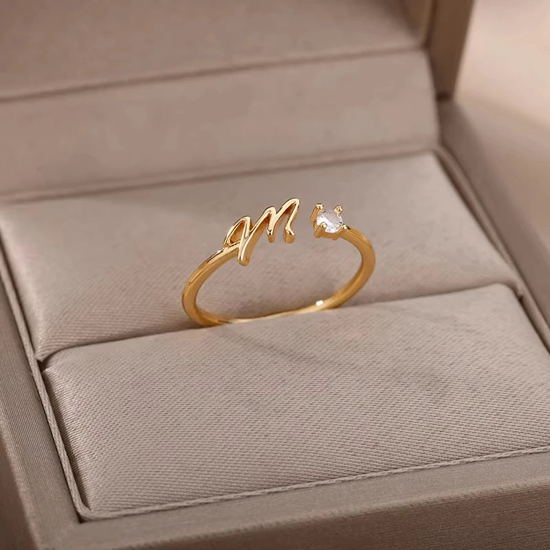 Infinity delicate gold ring featuring a modern script design accented with a small crystal, displayed elegantly in a soft beige jewelry box for a timeless luxury jewelry gift.
