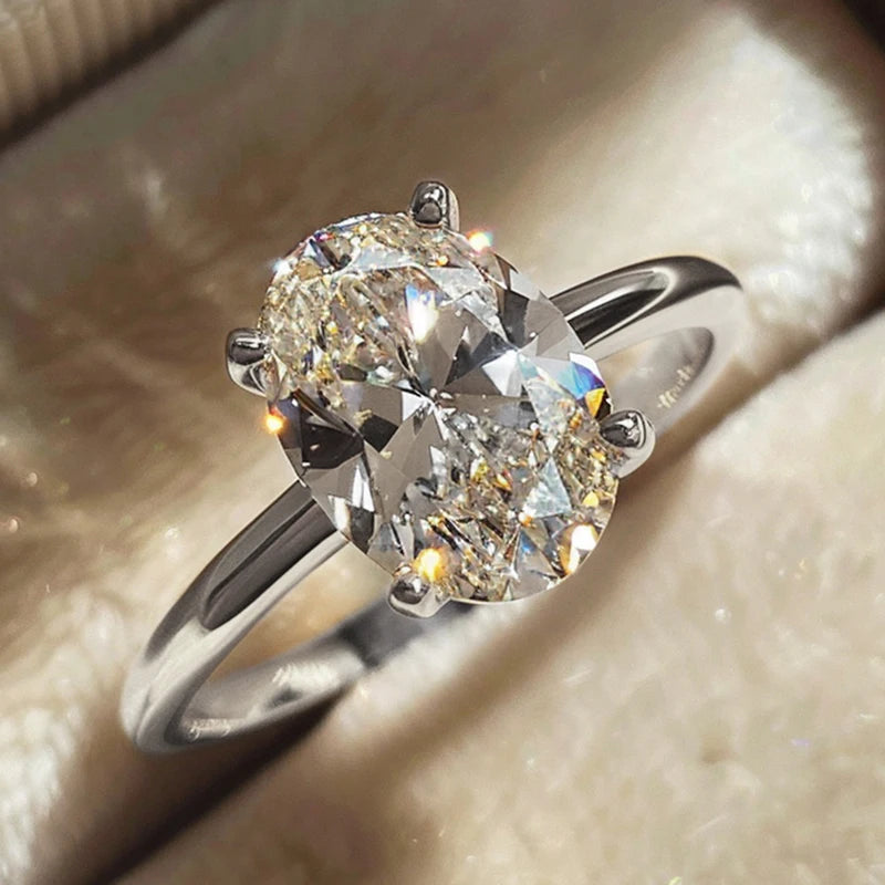 Close-up of a luxurious Harmony Ring featuring a sparkling oval-cut diamond set on a sleek polished band, embodying timeless elegance and modern sophistication.